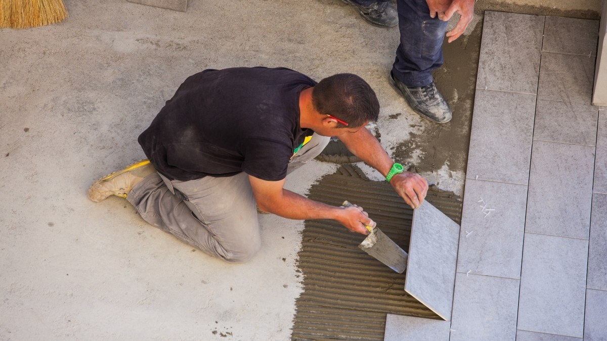 worker kneeling on a concrete floor