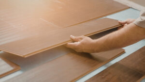 person installing wood-look click-lock planks
